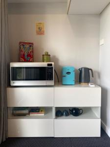 a microwave sitting on top of a white cabinet at The Elephants Nest in Victor Harbor