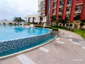a swimming pool in front of a building at Prime World District Condo in Pajak