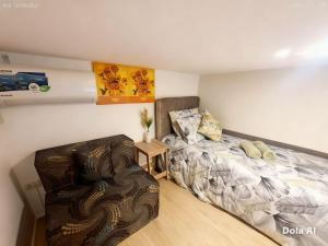 a bedroom with a bed and a chair in it at Prime World District Condo in Pajak
