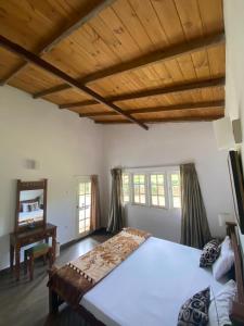 a bedroom with a large bed and a desk at Whispering Hills in Nuwara Eliya
