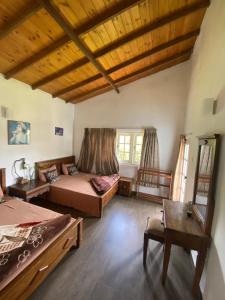 a large room with two beds and a table at Whispering Hills in Nuwara Eliya