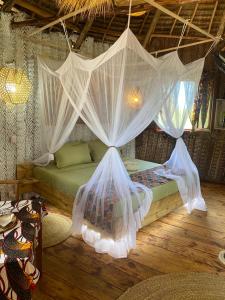 a bedroom with a bed with mosquito netting at Baobab Lagoon in Mtende