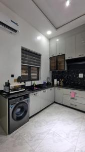 a kitchen with a washer and a dishwasher at F&F Luxury Residence in Lekki