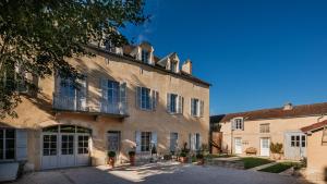 an old building in the middle of a courtyard at Le Clos du Colombier 1817 Vignes & Spa in Pommard