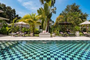 a pool at a resort with chairs and umbrellas at Moorea Boutique Resort Samui in Ban Tai