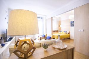 uma sala de estar com um sofá e uma mesa com um candeeiro em Carmo in Chiado Apartment em Lisboa