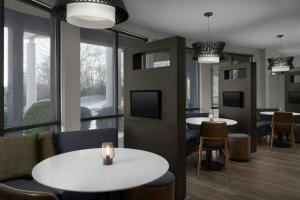 a restaurant with tables and chairs and large windows at Courtyard Danville in Danville