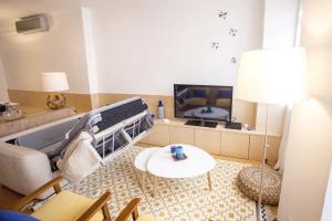 a living room with a couch and a tv at Carmo in Chiado Apartment in Lisbon