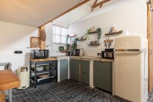 a kitchen with green cabinets and a white refrigerator at Somers Loft in Zuid-Beijerland