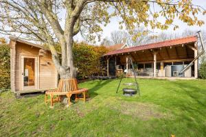 a bench sitting next to a tree in a yard at Somers Loft in Zuid-Beijerland