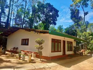a small white house with a green roof at Modern Nature Lodge - Private Holiday Home in Ella
