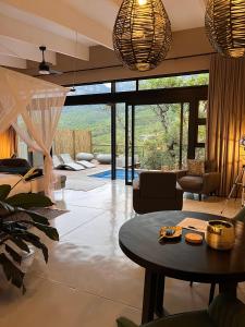 a living room with a table and a large window at Marepe Mountain View - Private villa with pool and unrivalled views in Kampersrus AH