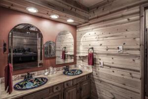 a bathroom with two sinks and a mirror at Whispering Pine Cabins in Ruidoso +189 photos