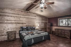 a bedroom with a bed and a ceiling fan at Whispering Pine Cabins in Ruidoso