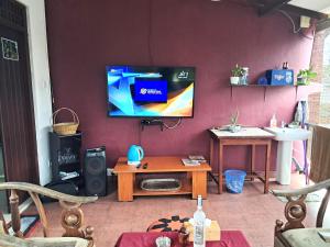 a living room with a tv on a wall at Vibes Home Stay in Athurugiriya