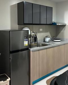a kitchen with a refrigerator and a sink at MERE Suite Davao- One Lakeshore behind SM Lanang in Davao City