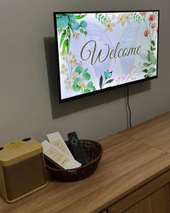 a television with a welcome sign on a table at MERE Suite Davao- One Lakeshore behind SM Lanang in Davao City