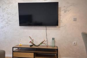 a flat screen tv hanging on a wall at Muki Oaza Apartman in Tuzla
