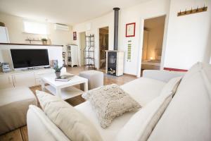 a living room with a white couch and a tv at Hacienda Lucio in Grohote