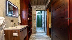 a bathroom with a sink and a wooden door at Termales del Arenal in Fortuna +31 photos