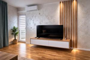 a living room with a flat screen tv on a wall at Hari Apartmani Oaza in Tuzla