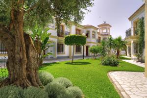 una casa grande con un árbol en el patio en Infinity Beach Resort Vera, en Vera