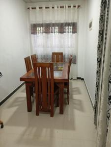 a dining room with a wooden table and chairs at Bright Nest Villa in Matara