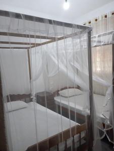 a bedroom with two bunk beds with white curtains at Bright Nest Villa in Matara +2 photos