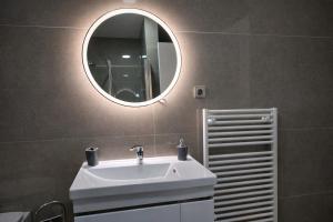 a bathroom with a white sink and a mirror at Muki Park Lake in Tuzla +8 photos