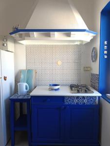 a blue kitchen with a sink and a stove at La Casa di Chico in Mondello