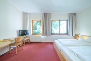 una habitación de hotel con una cama y un escritorio con ordenador en Hotel 26, en Berlín