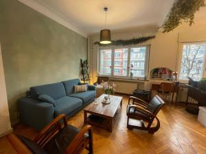 a living room with a blue couch and a table at Spacious Home in Brussels in Brussels