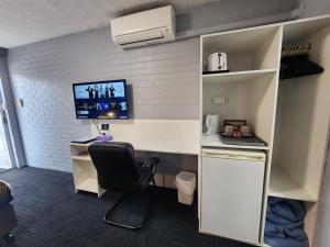 an office with a desk with a computer and a monitor at Crest Motor Inn in Queanbeyan
