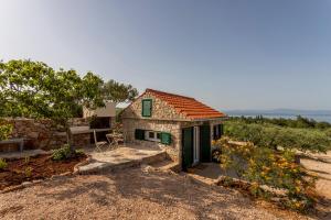 a small stone house with a bench and a table at Hacienda Lucio in Grohote