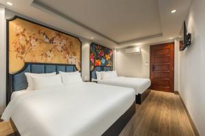 two white beds in a room with a painting on the wall at Aurora Hotel & Apartment in Hanoi +17 photos