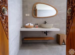 a bathroom with a sink and a mirror at Sananda Aryani in Lovina +30 photos