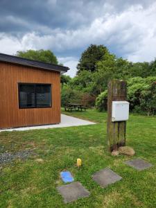 a utility box on a wooden pole in the grass at Clearwater Private Guest Suite in Dunedin +6 photos