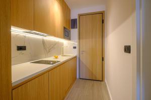 a kitchen with a sink and a counter with a door at Dubrave apartmani in Budva +16 photos