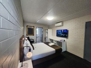 a small room with a bed and a tv at Crest Motor Inn in Queanbeyan +47 photos
