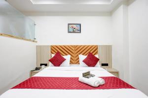 a bedroom with a bed with red and white pillows at Hotel Lee Paramount in Gandhinagar +57 photos