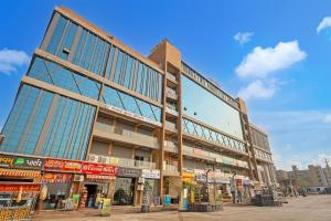 a large building with glass windows on a street at Hotel Lee Paramount in Gandhinagar