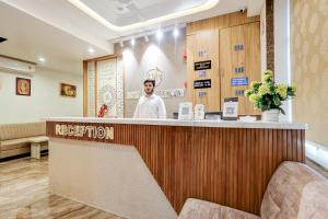 a chef standing behind a counter in a restaurant at Hotel Lee Paramount in Gandhinagar