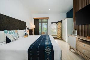 a bedroom with a large bed and a television at Sanur House in Sanur +60 photos