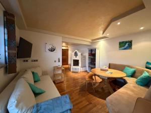a living room with a couch and a table at Feines Alpennest in Hopfgarten im Brixental