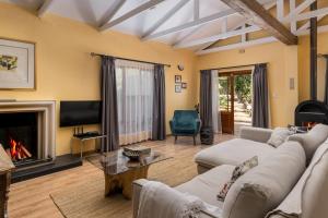 a living room with couches and a fireplace at Apricot Gardens Guesthouse in Gordonʼs Bay