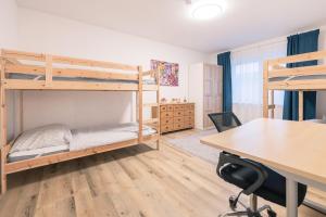 ein Schlafzimmer mit zwei Etagenbetten und einem Schreibtisch in der Unterkunft Haus Emma Großes Ferienhaus mit Garten für bis zu 10 Personen in Klosterdorf