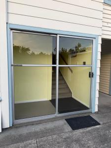 a sliding glass door of a house with a staircase at Delight On Dalton in Hokitika