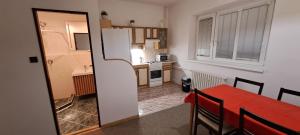 a kitchen with a red table and a white refrigerator at U Piškota in Desná