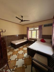 a bedroom with two beds and a ceiling fan at Hotel Shera Pokhara in Pokhara