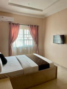 a bedroom with a large bed and a window at Nexus Xpress Hotel in Abuja